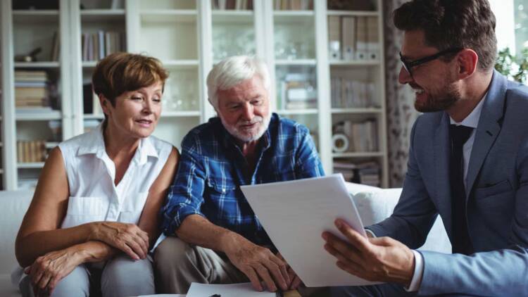 An elderly couple consulting with a private investor