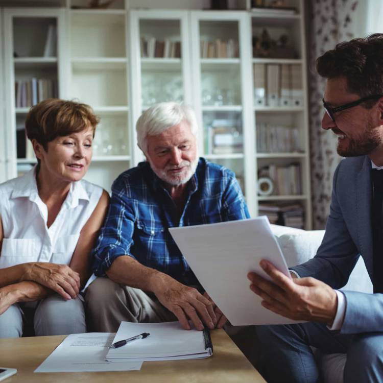 An elderly couple consulting with a private investor